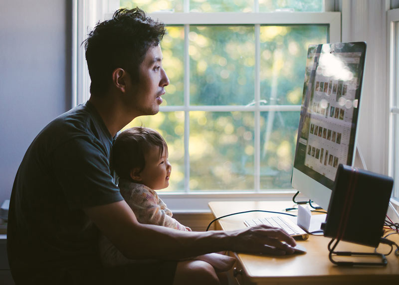 Dad and baby looking at photos on computer