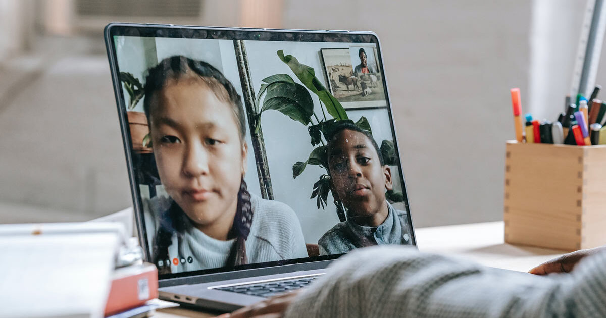 Kids video chatting with friend on laptop