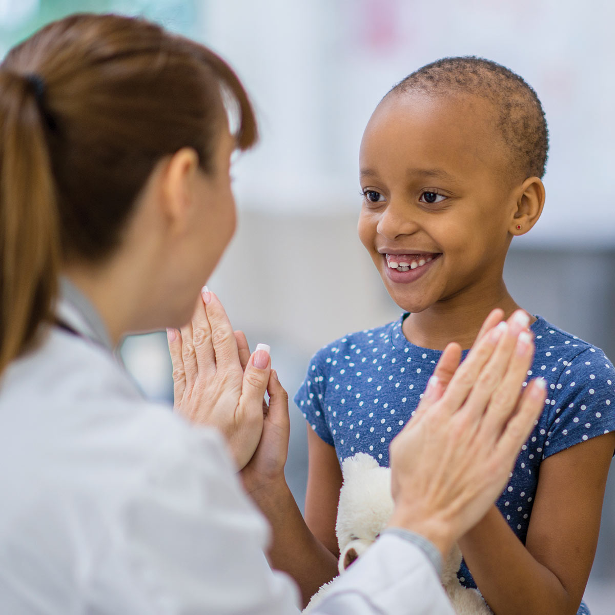 little girl doctor giving high fives
