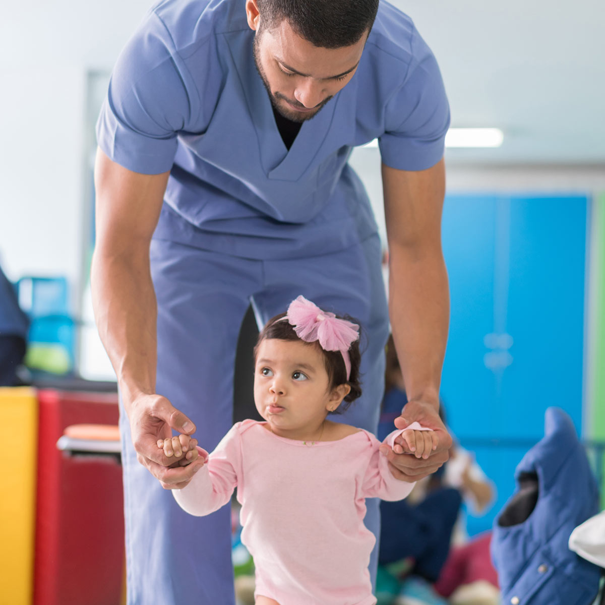 physical therapist helping little girl walk