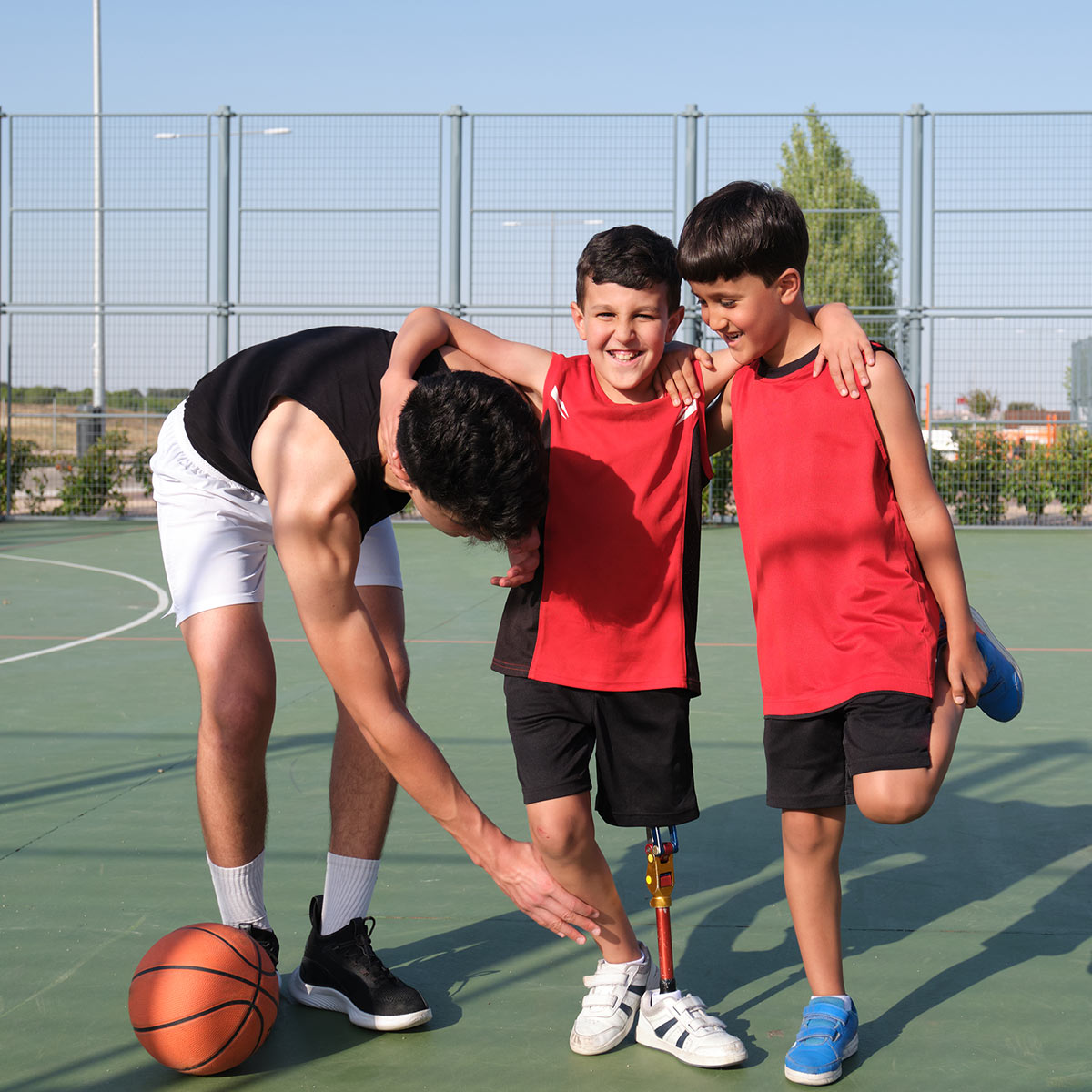 Boy with prosthetic leg playing basketball
