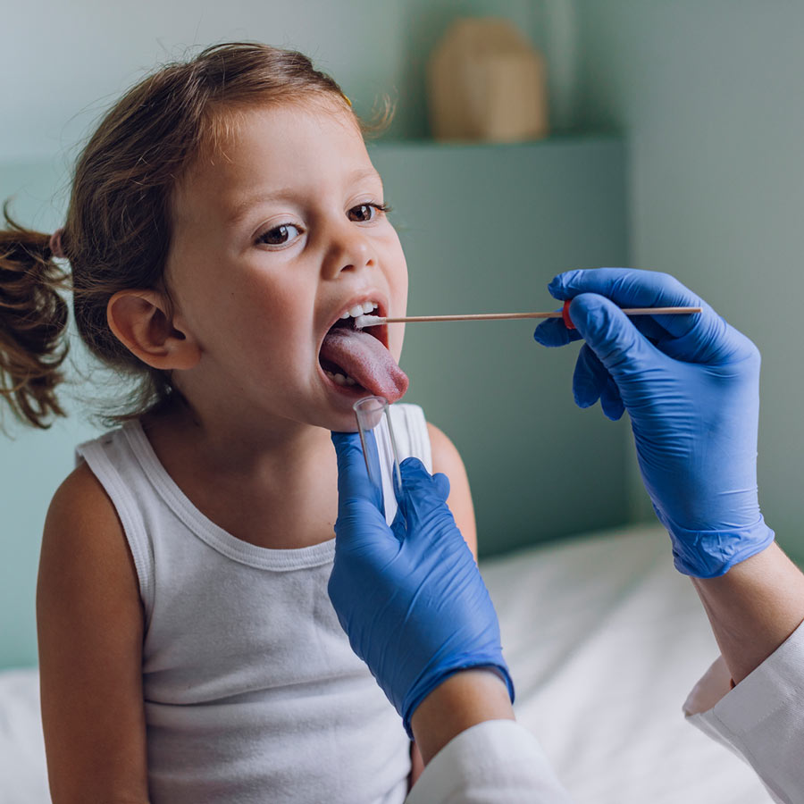 Nurse checking little girls tonsils