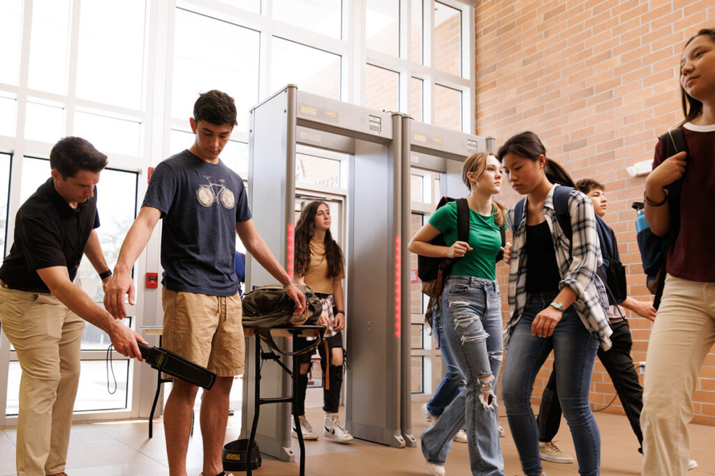 High schoolers going through metal detectors