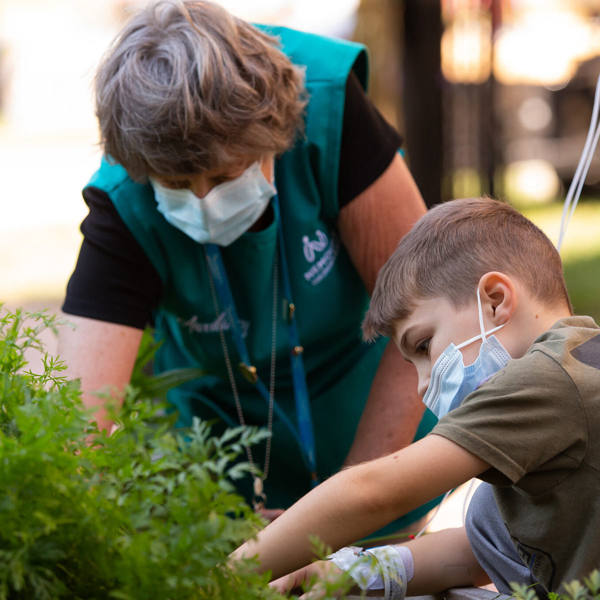 volunteer and patient working in herb garden