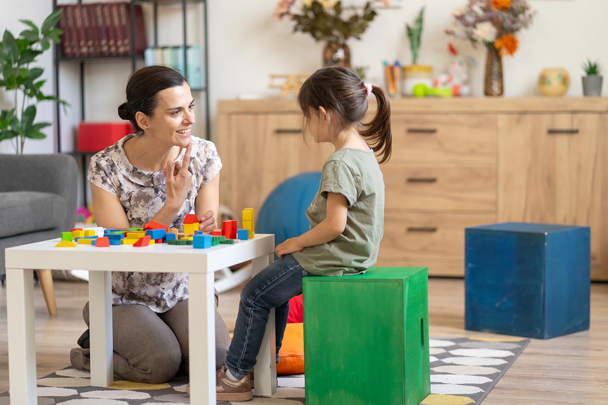 Woman cheering, child playing with blocks