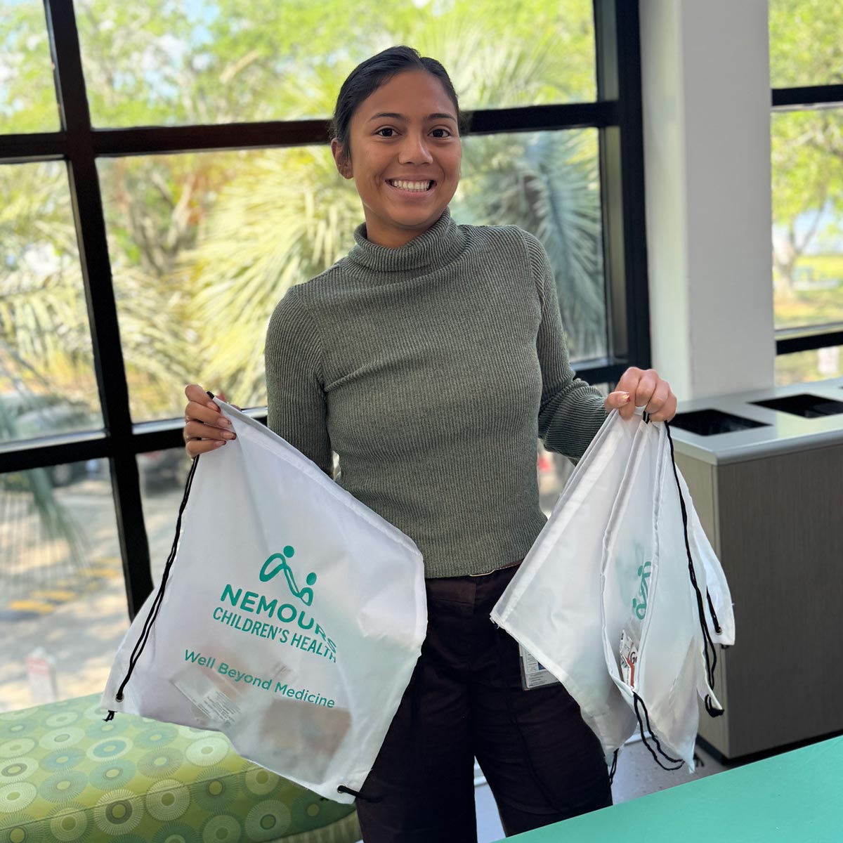 smiling woman holding Nemours bags