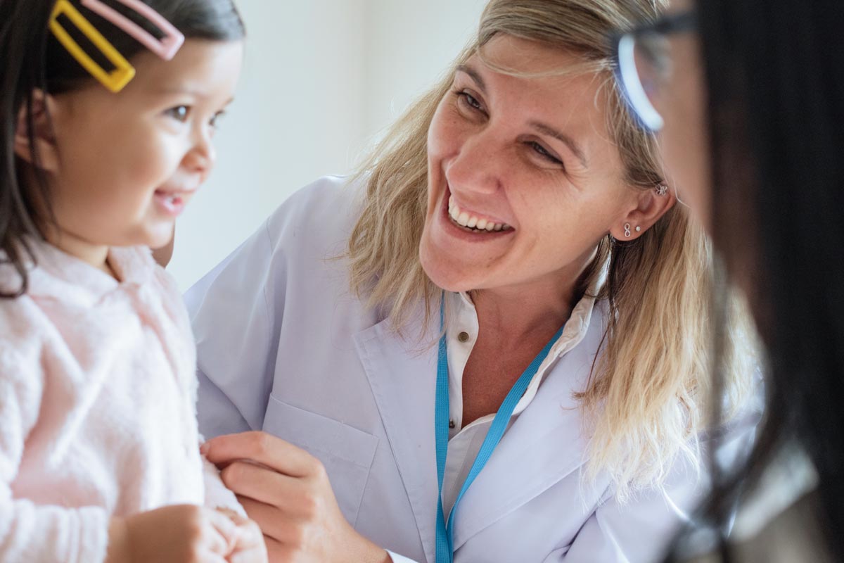 female pediatrician examining a little girl