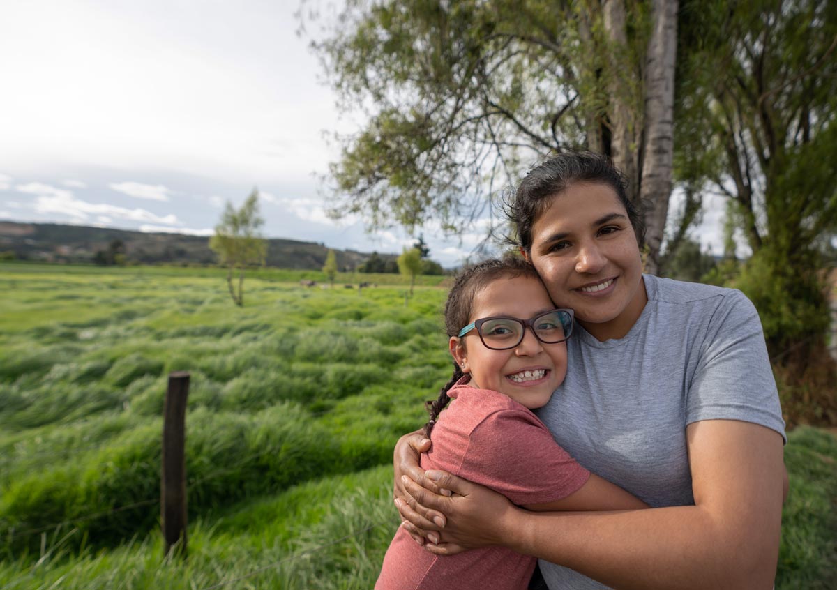 loving Latin American mother and daughter at a farm hugging