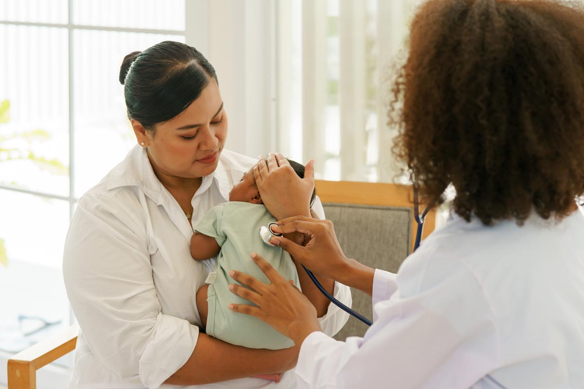 Mother and newborn baby boy visiting the doctor for health checkup