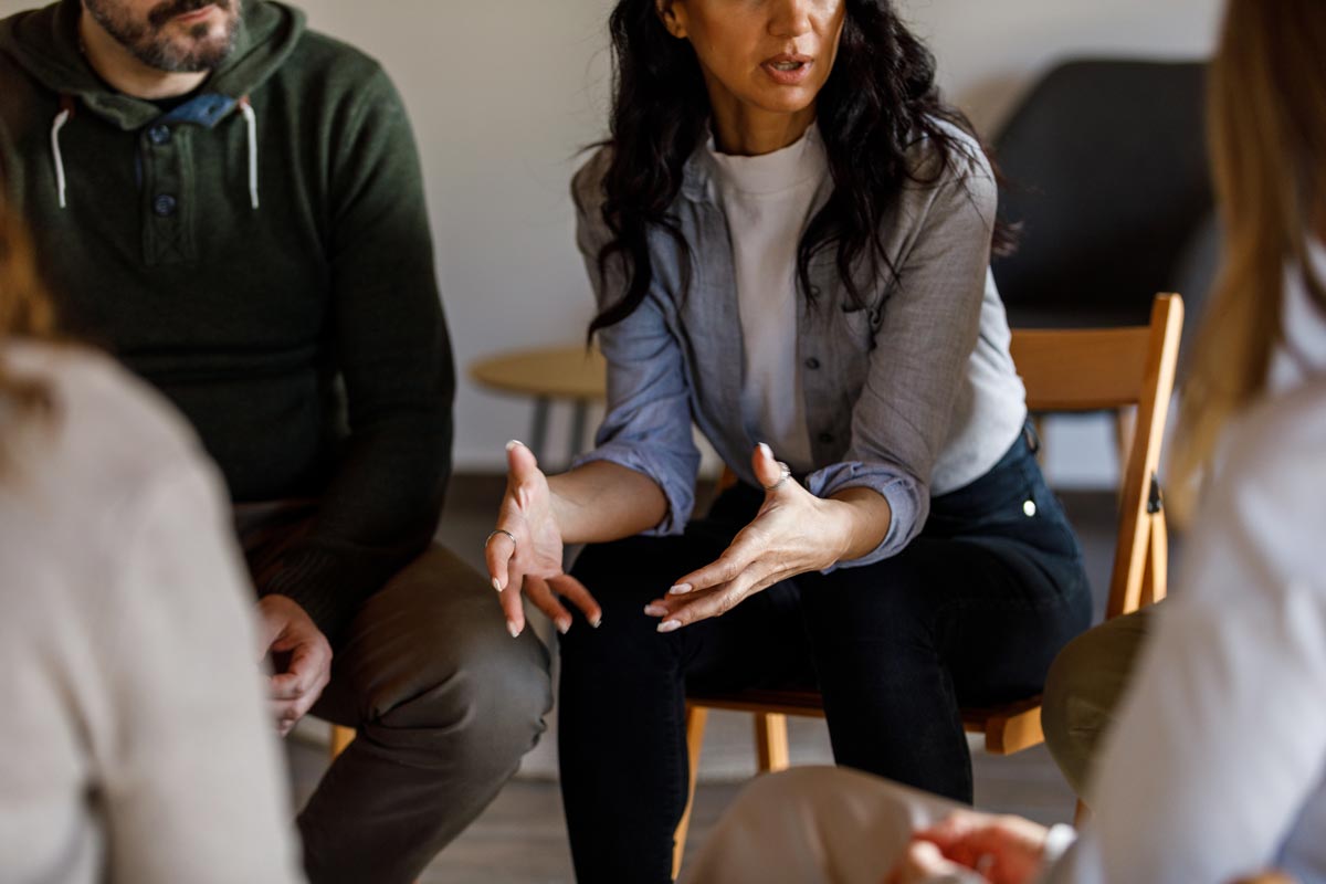 anxious woman sharing her struggles with her peers during a group therapy session
