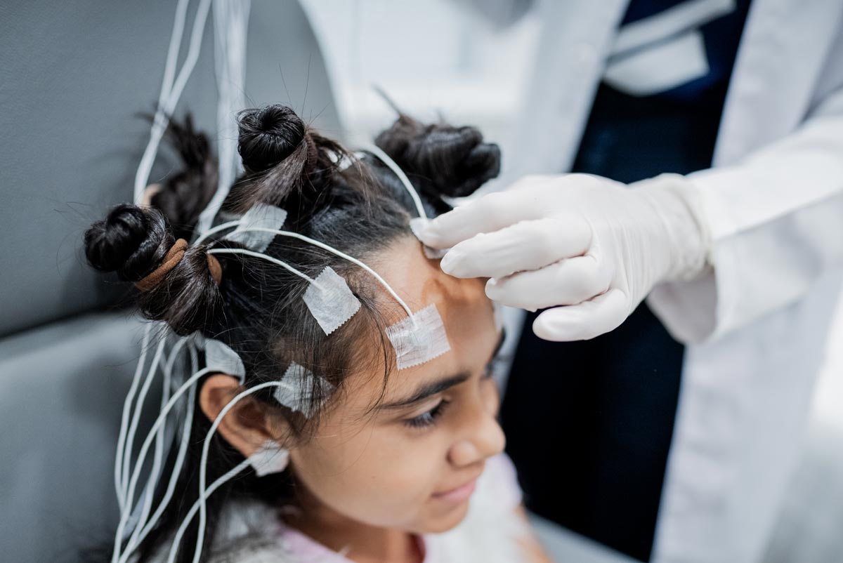 Doctor preparing a child patient to do polysomnography at medical clinic