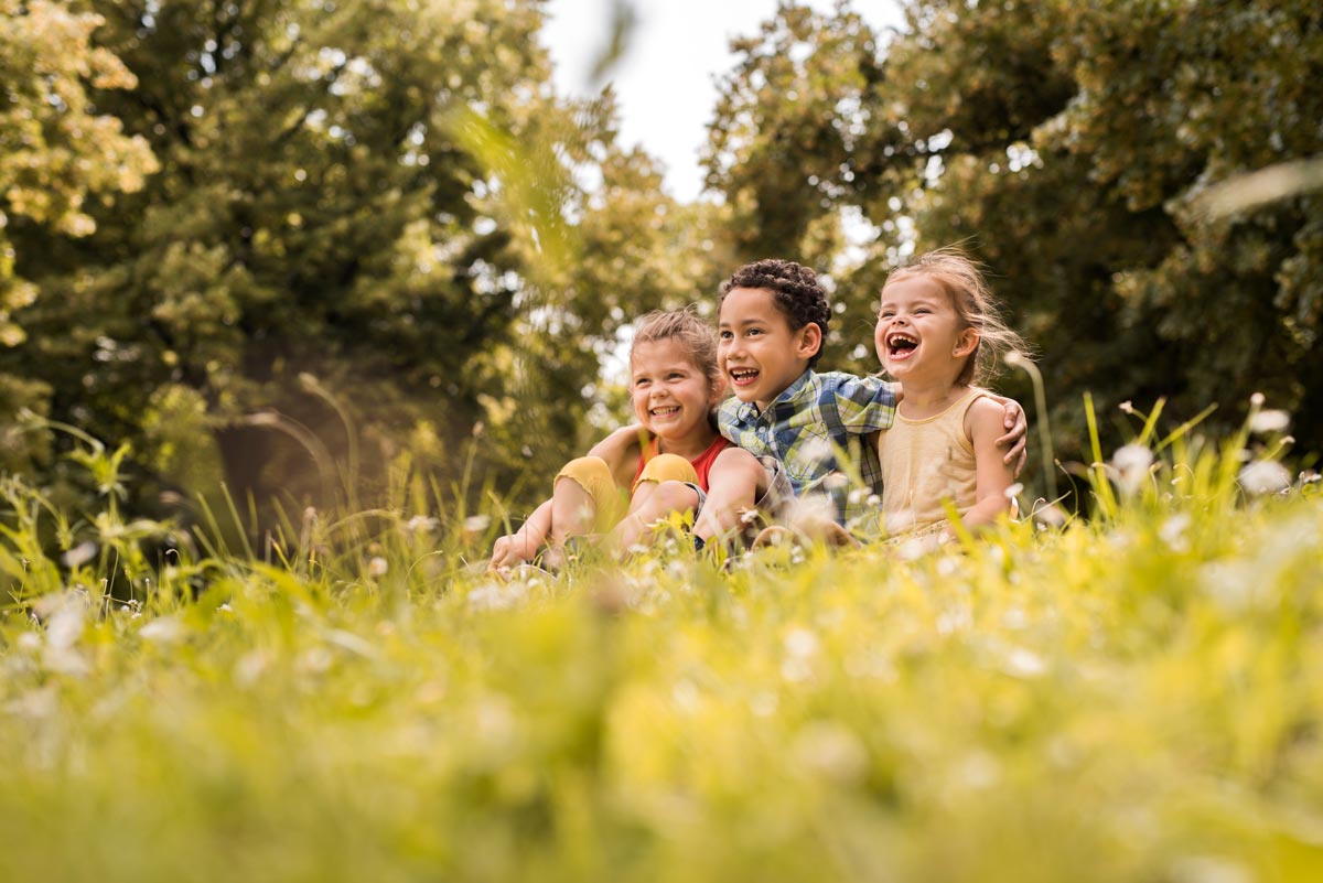 Happy embraced kids relaxing together in the park