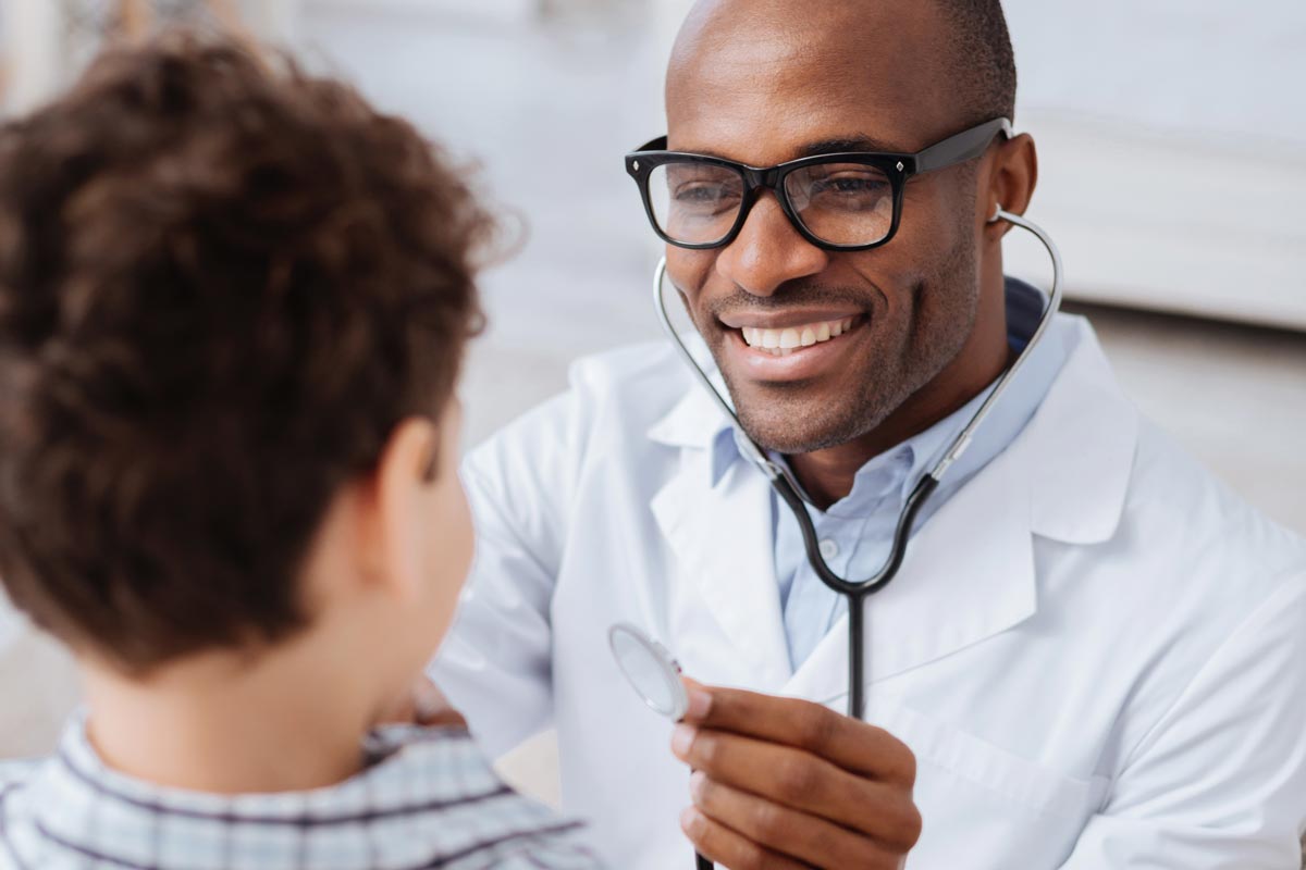 male doctor listening to boys lungs